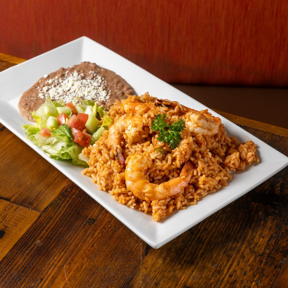 Frida's Mexican Grill's shrimp and rice dish with refried beans and a side salad.