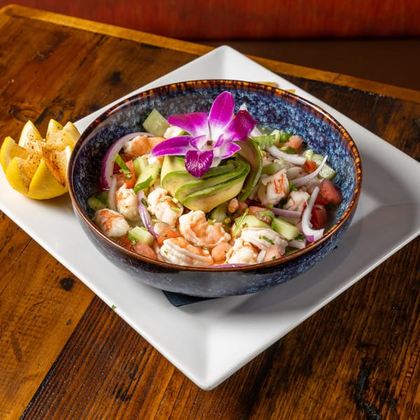 Frida's Mexican Grill's shrimp ceviche with avocado, red onion, and a purple orchid garnish.