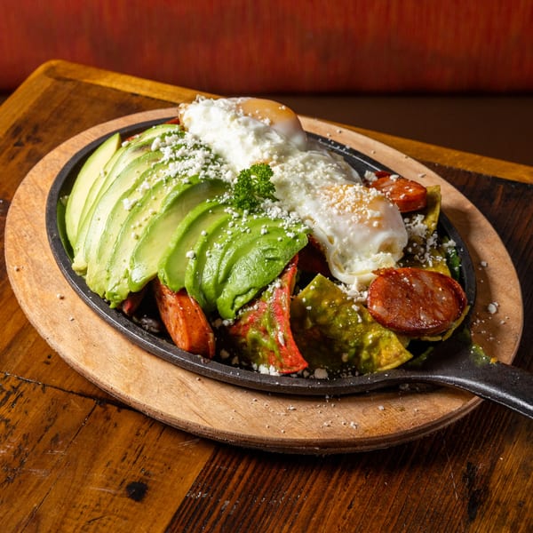 Frida's Mexican Grill's chilaquiles with sliced avocado, chorizo, fried eggs, and crumbled cheese.