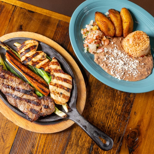 Frida's Mexican Grill's grilled steak and chicken fajitas with rice, beans, and plantains.