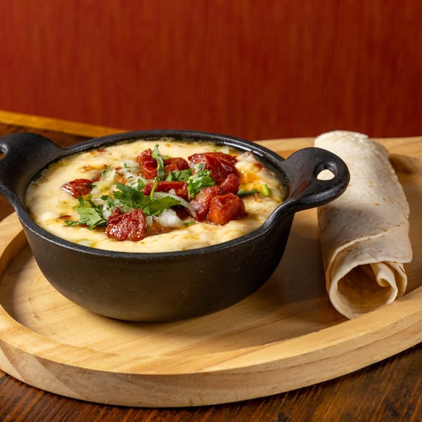 Frida's Mexican Grill's Queso Fundido with chorizo, onions, and cilantro, served with tortillas.
